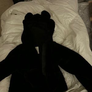 It’s a cropped black jacket for kids with little ears